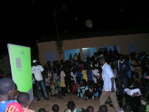 From ASVM, a member delivers mine risk education messages to a community at night.